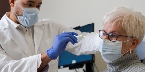 Patient preparing to receive ear curettage by physician.