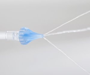 OtoClear tip spraying water for ear irrigation.
